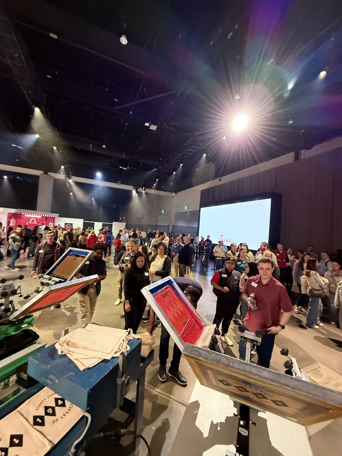 Busy live activation at an event with guests gathered around the custom printing stations